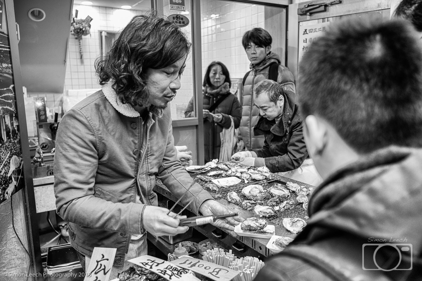 Tsukiji Market Trader serving fresh grilled oysters